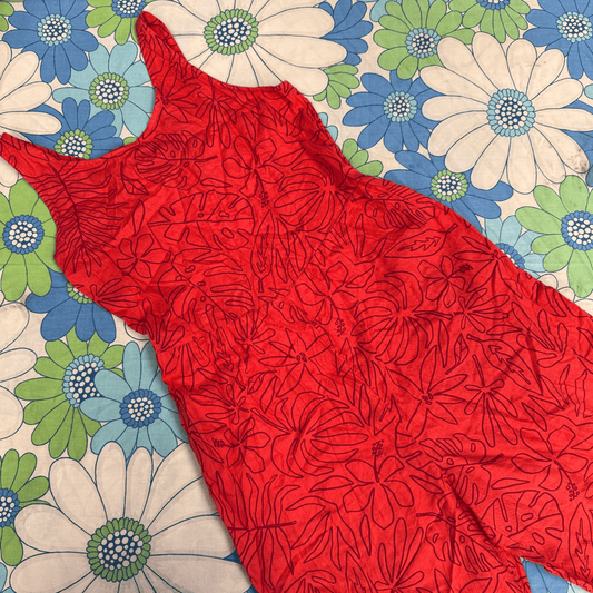 Red floral-patterned fabric jumpsuit on a colorful floral background
