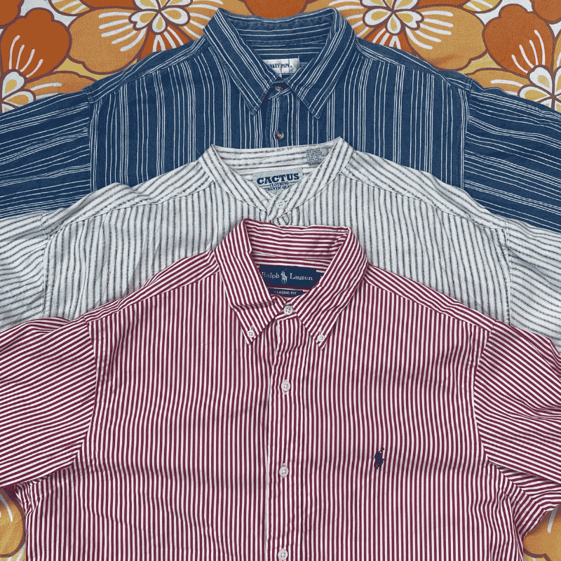 Three folded button-up shirts in red, white, and blue on a floral-patterned background